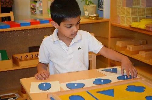A child fitting geometric shapes into their matching insets